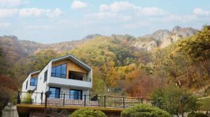 潭阳Damyang Lisa Forest Village的一座桥上的房子，背景是群山