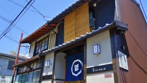 a building with a sign on the side of it at 京一軒町家 染 SEN 五条上長 Gojo Kamicho in Kyoto