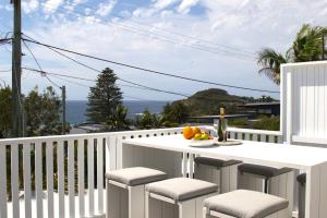 a balcony with a table and chairs with a bowl of fruit at Warriewood beach house in Mona Vale