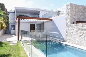 a house with a swimming pool in front of it at Warriewood beach house in Mona Vale