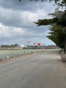 an empty street next to a beach with flags at Nhà Khách Hoàng Thắng in Bồng Sơn +16 photos