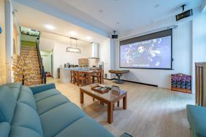 un soggiorno con divano blu e grande schermo di Green Inn a Wujie