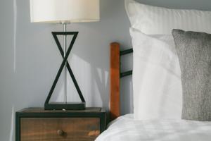 a lamp on a night stand next to a bed at 5D Guest House INFINITY in Naha +14 photos