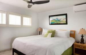 una camera con letto bianco e ventilatore a soffitto di 180 Ocean views Luxe condo Steps to Beach a Kihei