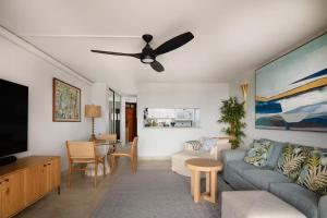 un soggiorno con un divano e una TV di 180 Ocean views Luxe condo Steps to Beach a Kihei