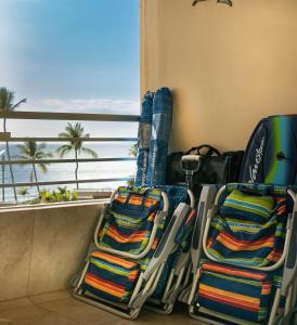 un gruppo di sedie seduti di fronte a una finestra di 180 Ocean views Luxe condo Steps to Beach a Kihei