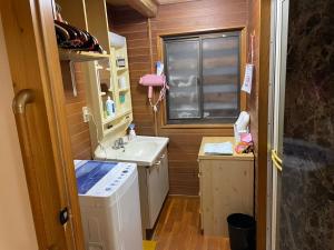 a small bathroom with a sink and a washing machine at 古民家 巳巳 in Tokamachi