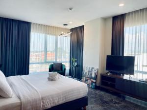 a hotel room with a bed and a television at Sibtis Hotel in Lampang