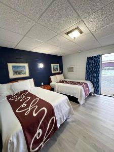 a hotel room with two beds and a window at Sleep-ees Inn, Saginaw & Frankenmuth in Saginaw