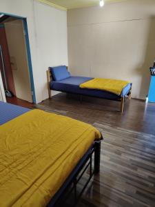 a room with two beds and a blue couch at Permata Beach Chalet in Kampong Juara
