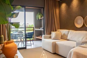 Il comprend un salon doté d'un canapé blanc et d'un balcon. dans l'établissement Gamboa Patacho - Refúgio exclusivo a apenas 150 metros da paradisíaca Praia do Patacho, à Porto de Pedras