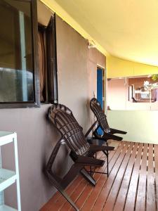two rocking chairs sitting on a wooden deck at Permata Beach Chalet in Kampong Juara