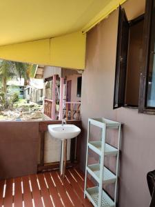 a bathroom with a sink and a shelf on a porch at Permata Beach Chalet in Kampong Juara