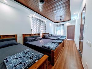 Una habitación con cuatro camas. en GaVi Stay's, en Sringeri