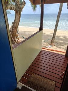 an open door to a beach with the ocean at Permata Beach Chalet in Kampong Juara