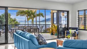 坎农代尔Whitsunday Escape - Beachfront with Private Pool的一间带蓝色家具的客厅和一个阳台
