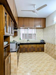 a large kitchen with wooden cabinets and a ceiling fan at Luxurious Apartment at Banani in Dhaka +18 photos