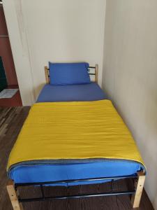 a bed in a small room with a yellow blanket at Permata Beach Chalet in Kampong Juara
