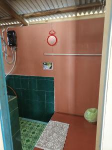 a bathroom with a shower with green tiles at Permata Beach Chalet in Kampong Juara