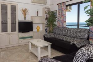 Apartamento Mediterraneo Side في مربلة: غرفة معيشة مع أريكة وتلفزيون