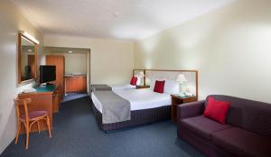 a hotel room with a bed and a couch at Bayswater Motel in Tweed Heads