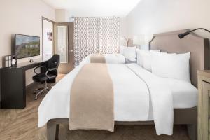 a bedroom with a large white bed and a desk at Hollywood Hotel in Los Angeles