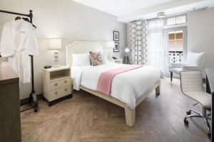 a white bedroom with a bed and a chair at Hollywood Hotel in Los Angeles
