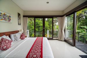 a bedroom with a bed with red and white pillows at Mardika Private Villa Ubud in Ubud