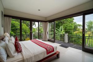 a bedroom with a bed and a balcony at Mardika Private Villa Ubud in Ubud