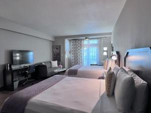 a hotel room with two beds and a television at Hollywood Hotel in Los Angeles