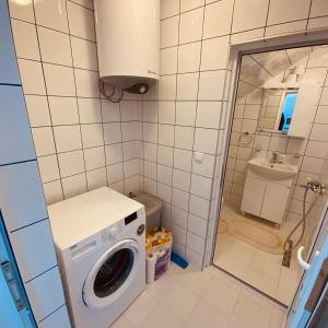 a small bathroom with a washing machine in it at Green Village Park in Dobrich