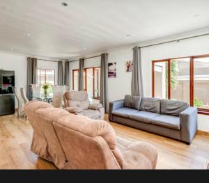 una sala de estar con un sofá y dos sillas en Heartwood haven, en Sandton