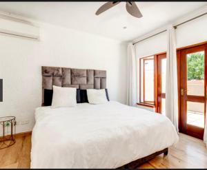 1 dormitorio blanco con 1 cama grande con sábanas blancas en Heartwood haven, en Sandton 5 fotos más
