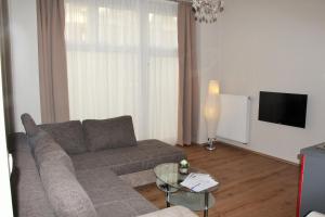 a living room with a couch and a television at Stars Berlin Apartments Zillestraße in Berlin