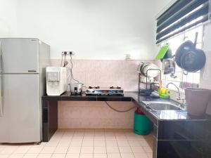 a kitchen with a white refrigerator and a sink at Ciksiti homestay landed 05 in Kajang