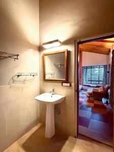 ein Badezimmer mit einem weißen Waschbecken und einem Spiegel in der Unterkunft Mountain View 3bhk Near Mall Road Deodar Retreat in Dalhousie