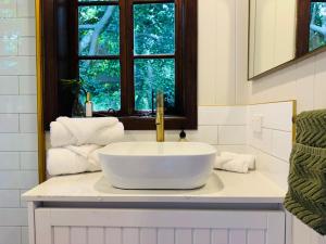 a bathroom with a white sink and a window at Misty Valley Cottage in Mapleton +32 photos