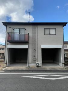 a building with two garage doors with a balcony at inn 2nd in Kurashiki
