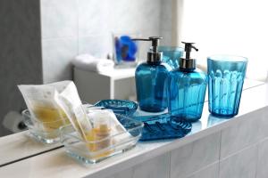 un bancone del bagno con bottiglie di vetro blu di Lux Appartamenti a Roma