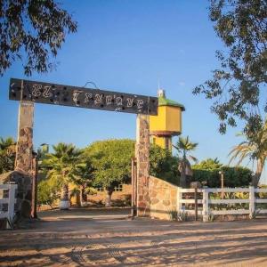 a gate with a sign in front of a building at Bungalo en Valle de Guadalupe in Ensenada +2 photos