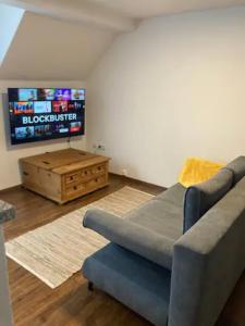 a living room with a couch and a flat screen tv at Wunderschön gelegene Ferienwohnungen im Zentrum von Zell an der Mosel in Zell an der Mosel