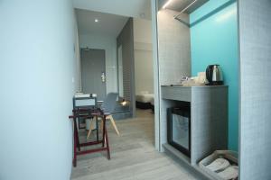 a room with a kitchen with a counter and a table at Stanton City Hotel in Kota Kinabalu