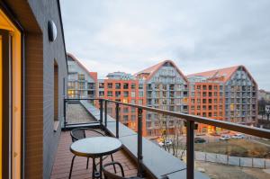 balkon ze stołami, krzesłami i budynkami w obiekcie Dom & House - Apartments Chmielna Park w Gdańsku