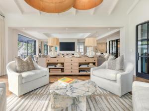 a living room with two chairs and a tv at Russet Rise, Adults Only in Cape Town