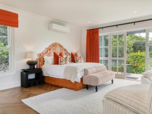a bedroom with a bed and a chair and windows at Russet Rise, Adults Only in Cape Town +49 photos