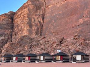 a row of buildings in front of a mountain at Wadi Rum Story Camp in Wadi Rum
