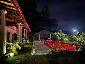 una casa con giardino con piscina di notte di Summer Heritage Villa a Unawatuna