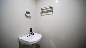 Baño blanco con lavabo y radiador en Nice and Comfy Studio at Grand Dharmahusada Lagoon Apartment By Travelio, en Surabaya 9 fotos más