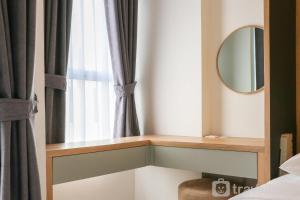 a bedroom with a mirror and a window at Well Furnished Studio at Citra Living Apartment By Tarvelio in Jakarta