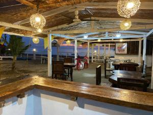 a restaurant with tables and chairs and chandeliers at Sakâ Sakâ Beach House in Sipalay
